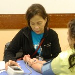 Malou Aclan, RN, Care Manager performing BP screening 