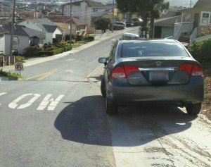 Cars parked on the sidewalk pose a dangerous obstacle course for pedestrians