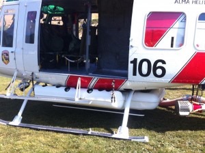 Rescue equipment is coming out of the chopper. Underneath the chopper is a white tank that holds 360 gallons of water. Photo: City of Brisbane