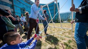 Mentors and students launch water-filled medical gloves to learn about projectile motion and velocity.  Photo from the Genentech archives.