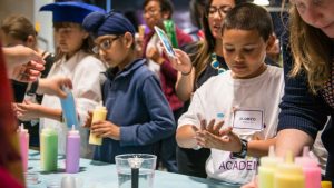 Students learn how “disease” spreads using colored water.  Photo from the Genentech archives.