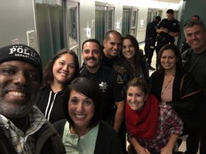 Stanley Roberts, KRON 'People Behaving Badly' personality takes a selfie with SSFPD officers, family and friends of Officer Chon's upon the good news