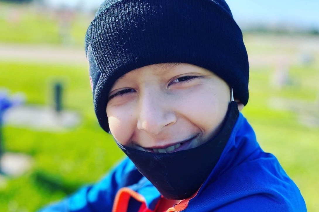 A kid wearing a mask and a hat