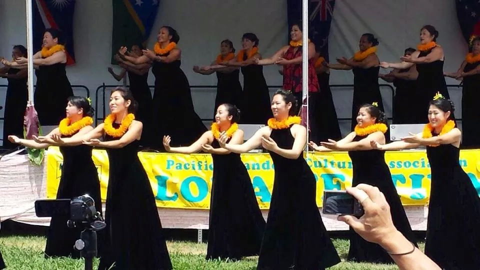 Women wearing black dresses and orange necklaces