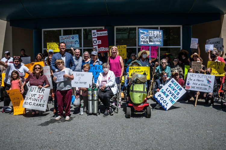 People outside a building holding placards with different colors