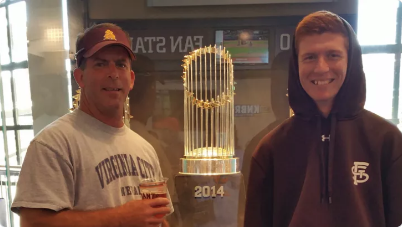 Two men, one wearing a cap and the other a hoodie