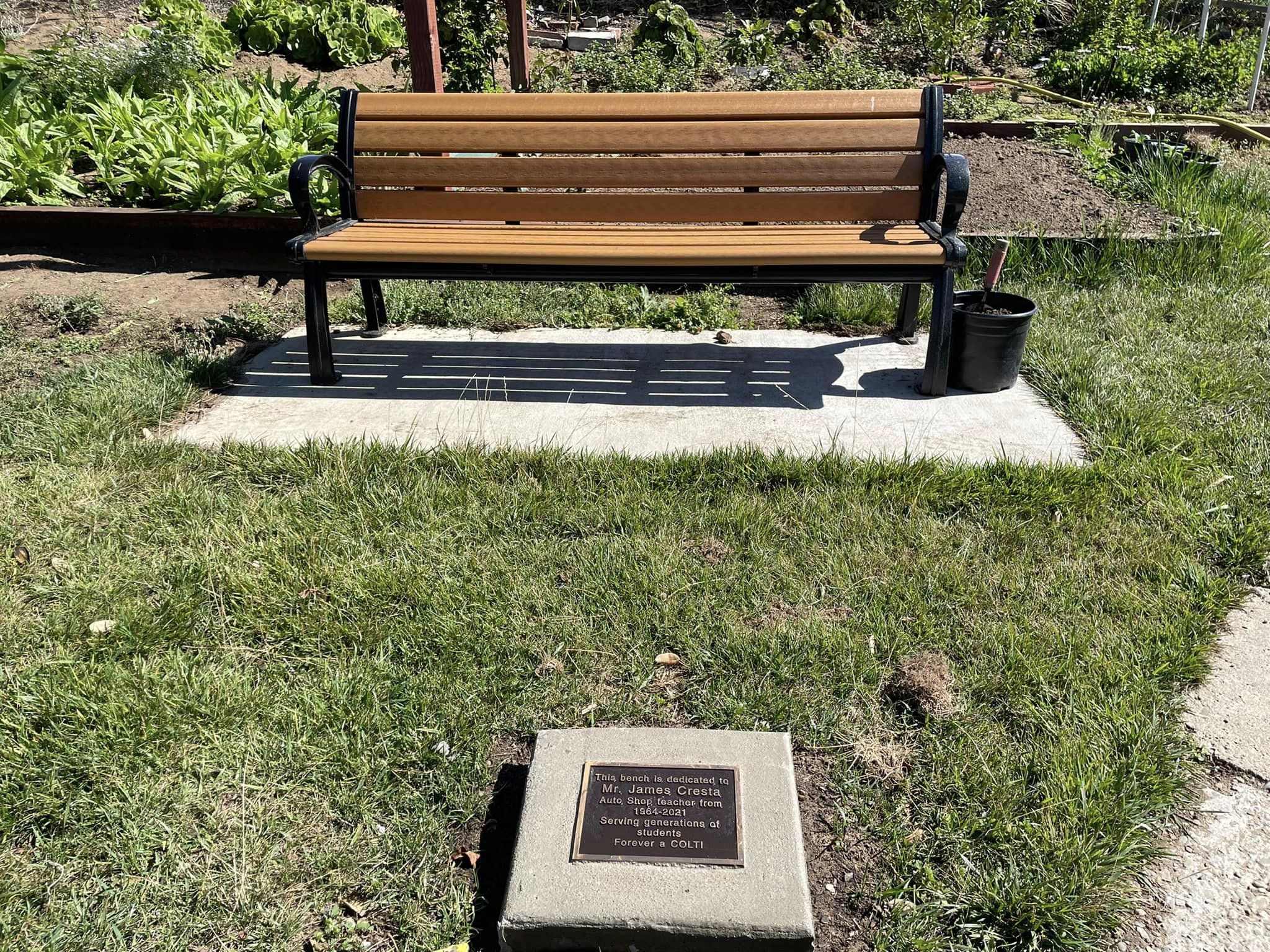 A bench. “This bench is dedicated to Mr. James Cresta…”